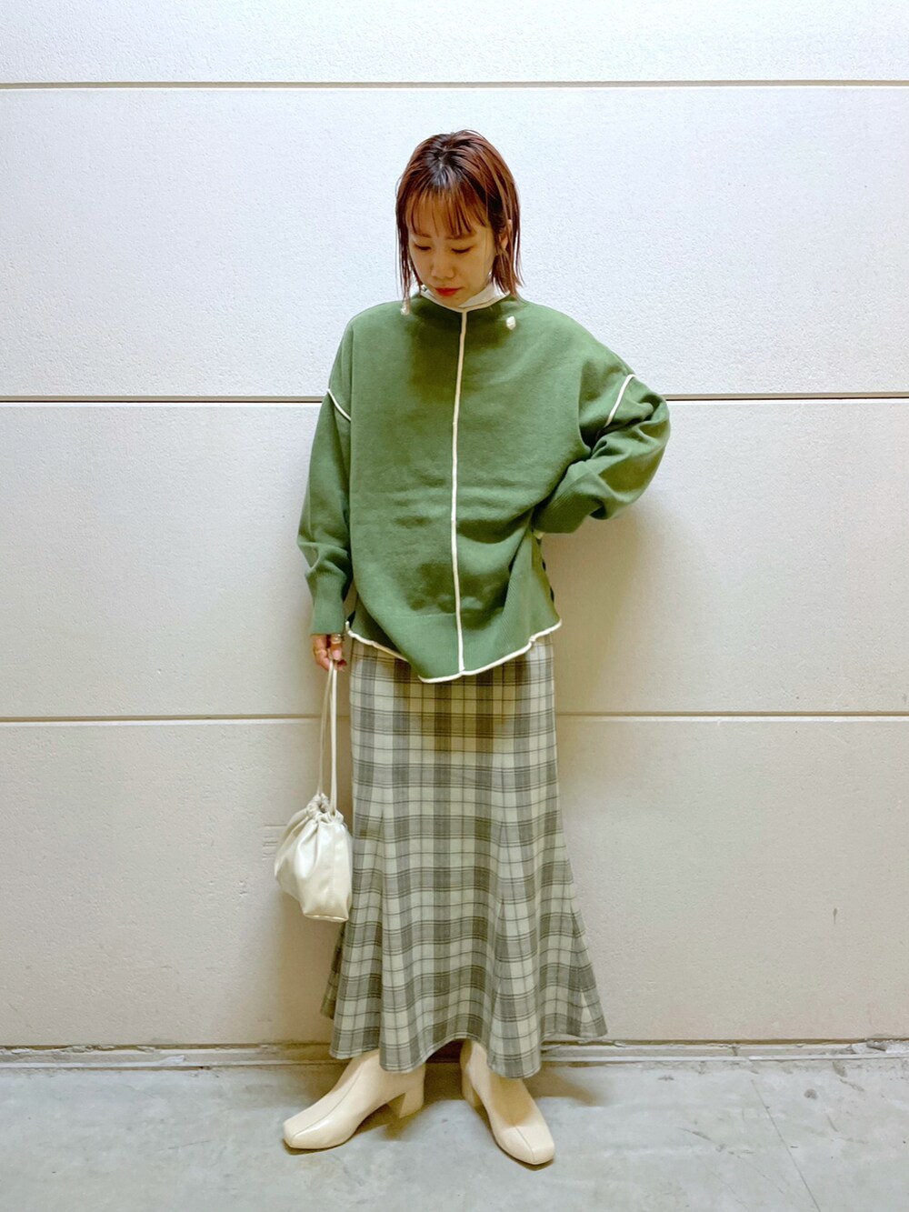 ホワイト系のブーツ、ホワイト系のスカート、ホワイト系のショルダーバッグを着用したレディースの秋コーディネートの3枚目の写真