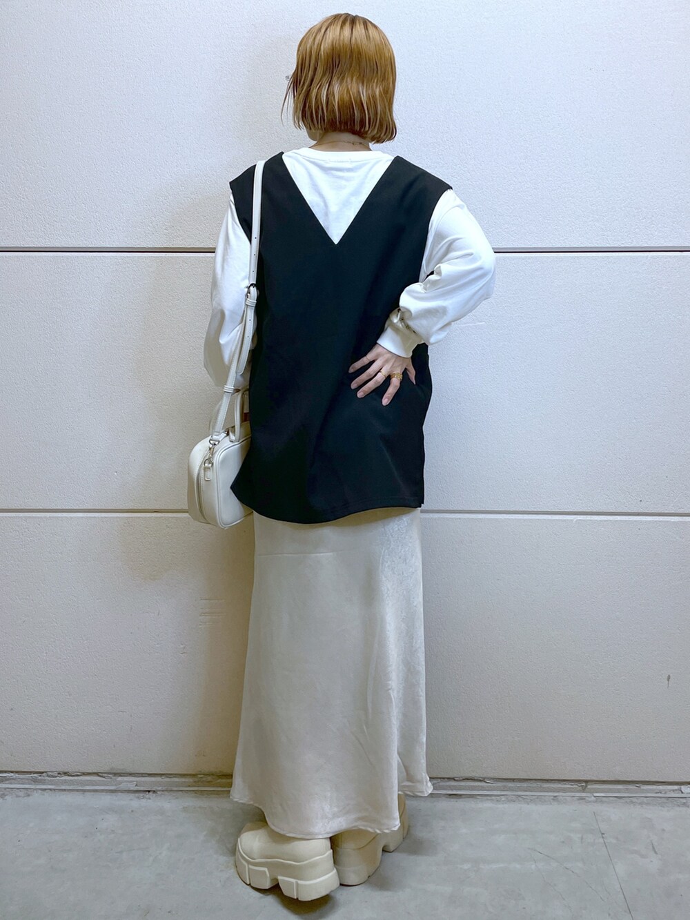 ホワイト系のブーツ、ホワイト系のTシャツ/カットソー、ブラック系のベストを着用したレディースの秋コーディネートの3枚目の写真