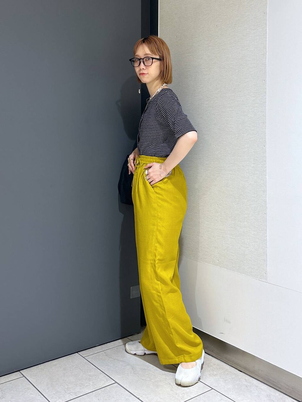 ブラック系のショルダーバッグ、イエロー系のその他パンツ、その他のカーディガン/ボレロを着用したレディースの夏コーディネートの6枚目の写真