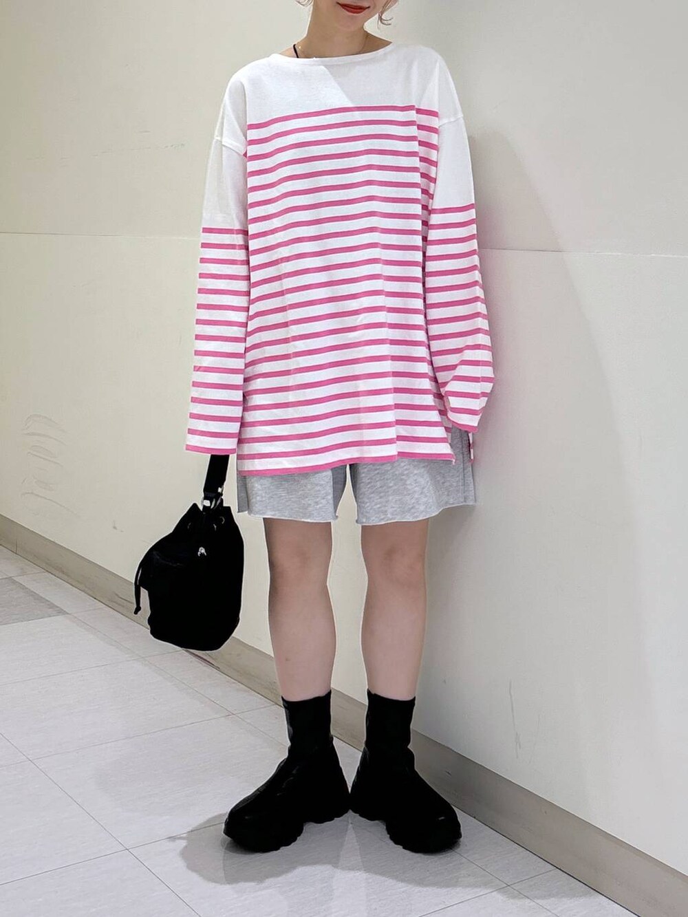 ブラック系のブーツ、グレー系のスウェットパンツ、ブラック系のショルダーバッグを着用したレディースの秋コーディネートの6枚目の写真