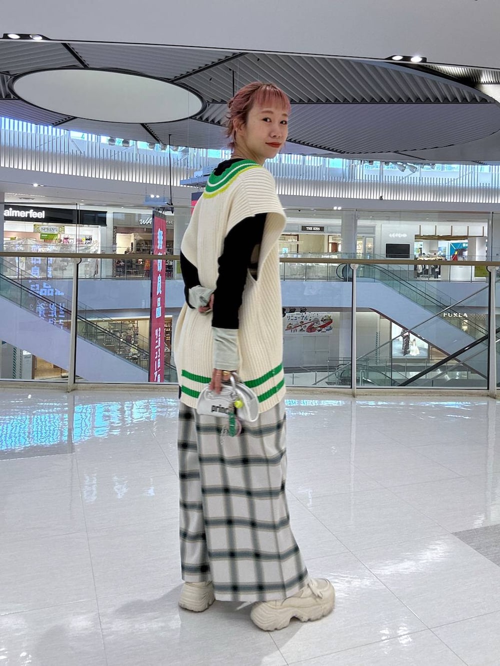 グレー系のTシャツ/カットソー、ホワイト系のサロペット/オーバーオール、ホワイト系のニット/セーターを着用したレディースの冬コーディネートの4枚目の写真