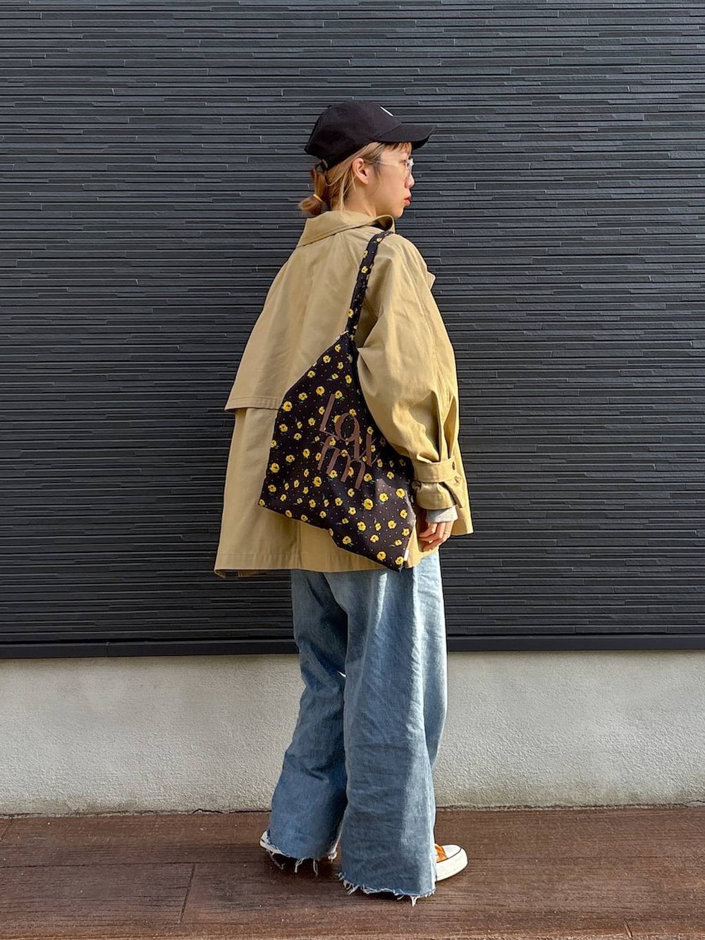 ブラウン系のトレンチコート、ブルー系のデニムパンツ、その他のネックレスを着用したレディースの春コーディネートの7枚目の写真