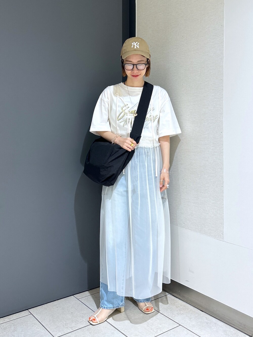 ブルー系のデニムパンツ、イエロー系のTシャツ/カットソー、ホワイト系のワンピースを着用したレディースの夏コーディネートの6枚目の写真