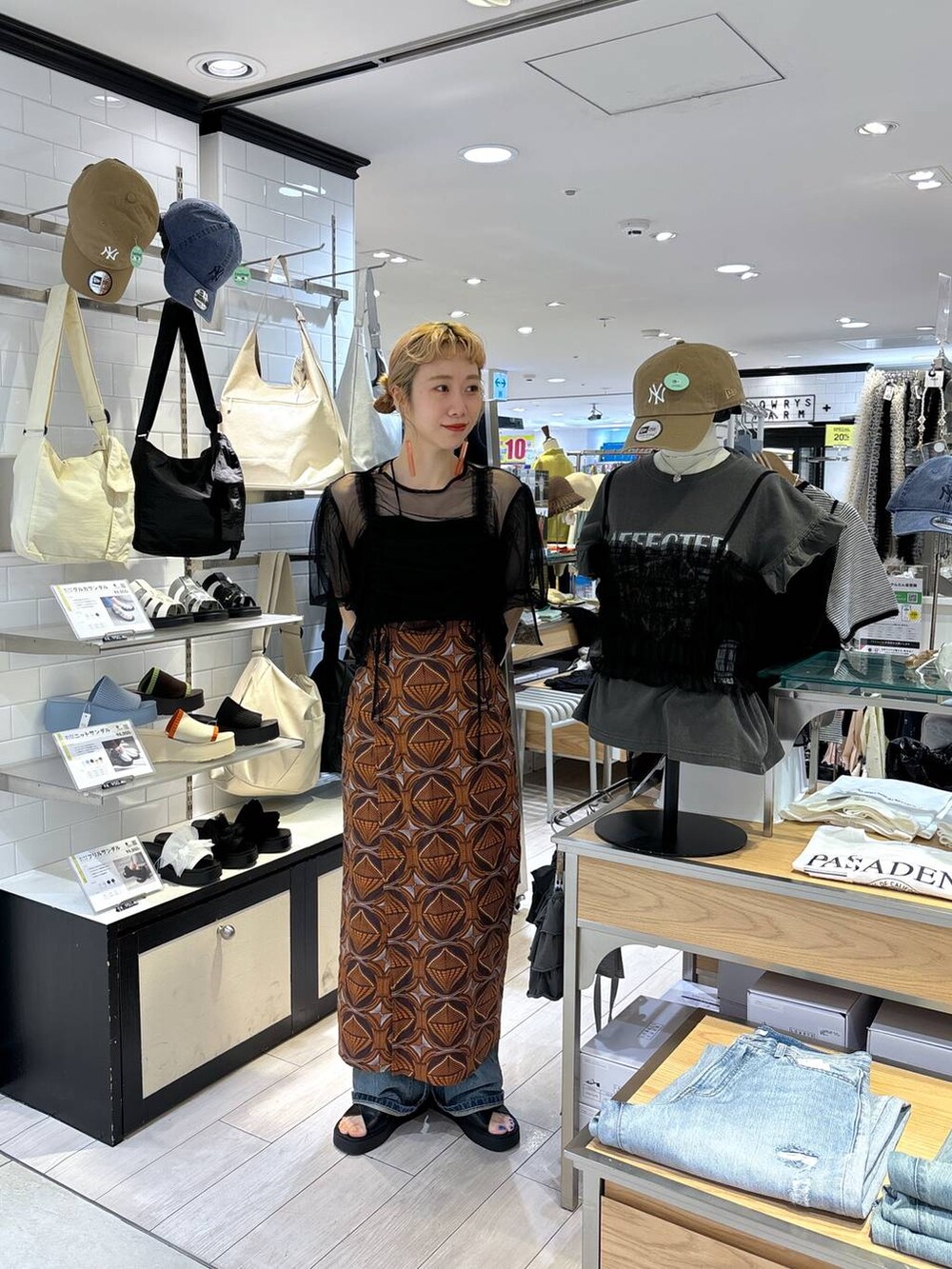 ブラック系のトートバッグ、ブラウン系のスカート、ブラック系のサンダルを着用したレディースの春コーディネートの8枚目の写真