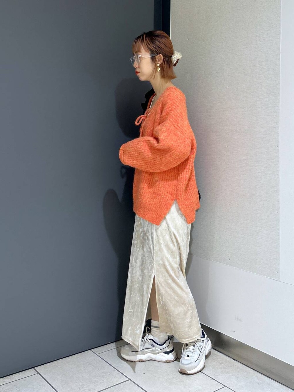 ホワイト系のタンクトップ、オレンジ系のニット/セーター、ホワイト系のスカートを着用したレディースの秋コーディネートの3枚目の写真