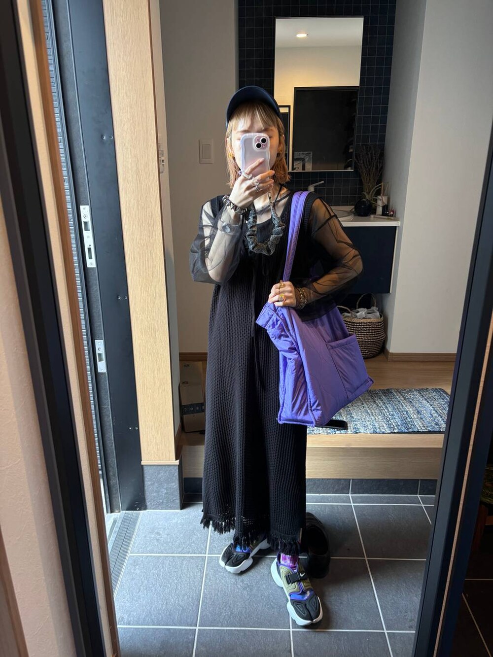 ブラック系のワンピース、パープル系のショルダーバッグ、ブラック系のスカートを着用したレディースの春コーディネートの8枚目の写真