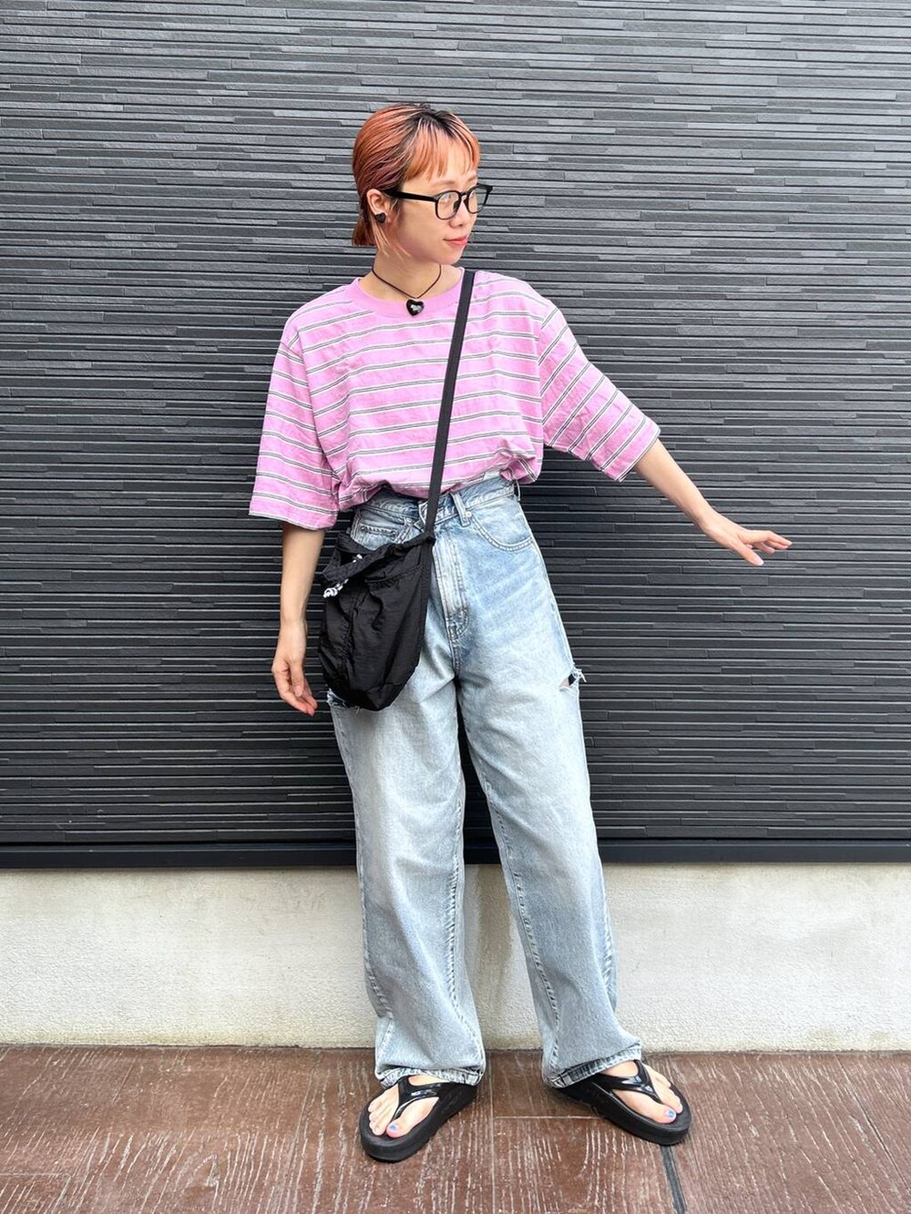 ピンク系のTシャツ/カットソー、ブラック系のショルダーバッグ、ブルー系のデニムパンツを着用したレディースの夏コーディネートの3枚目の写真