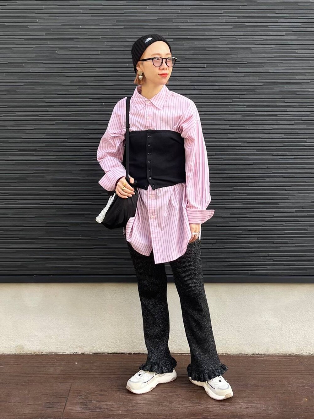 ブラック系のショルダーバッグ、ブラック系のベスト、ブラック系のその他パンツを着用したレディースの秋コーディネートの2枚目の写真