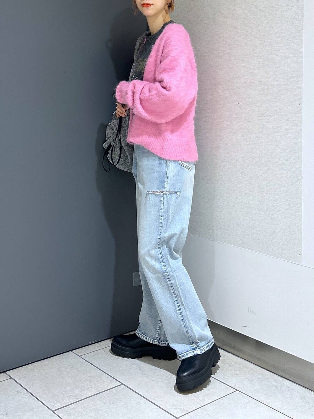 ブルー系のデニムパンツ、シルバー系のショルダーバッグ、ピンク系のカーディガン/ボレロを着用したレディースの冬コーディネートの4枚目の写真