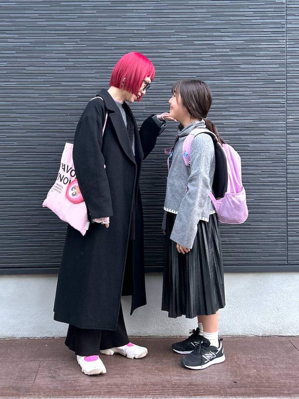 ピンク系のTシャツ/カットソー、グレー系のニット/セーター、ブラック系のスカートを着用したレディースの冬コーディネートの8枚目の写真