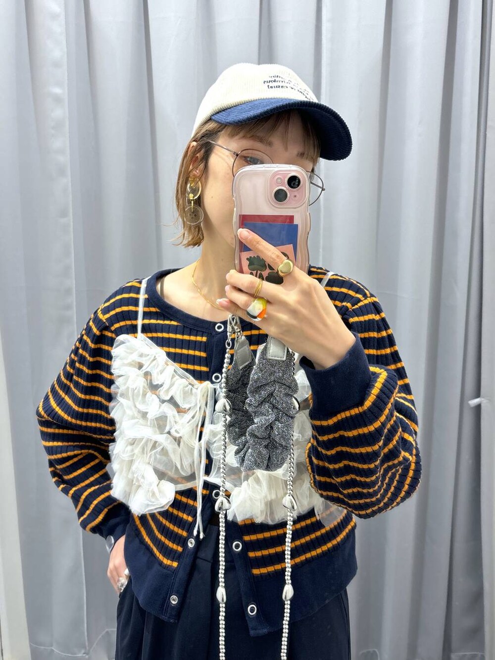 ホワイト系のキャミソール、グレー系のスマホグッズ、ブルー系のキャップを着用したレディースの秋コーディネートの8枚目の写真