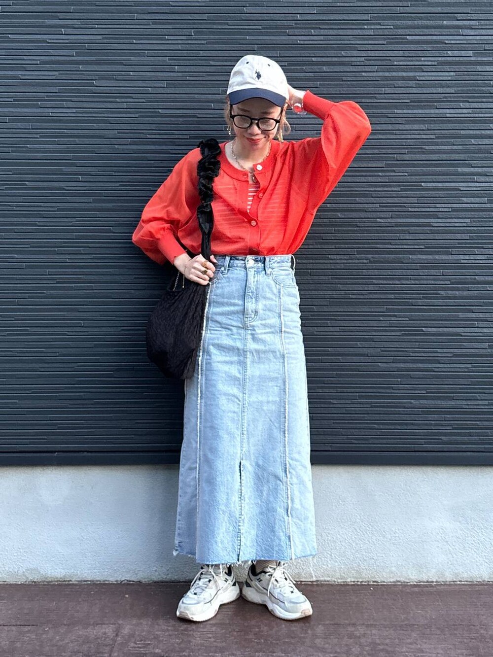 ブラック系のトートバッグ、オレンジ系のカーディガン/ボレロ、ブルー系のスカートを着用したレディースの夏コーディネートの5枚目の写真