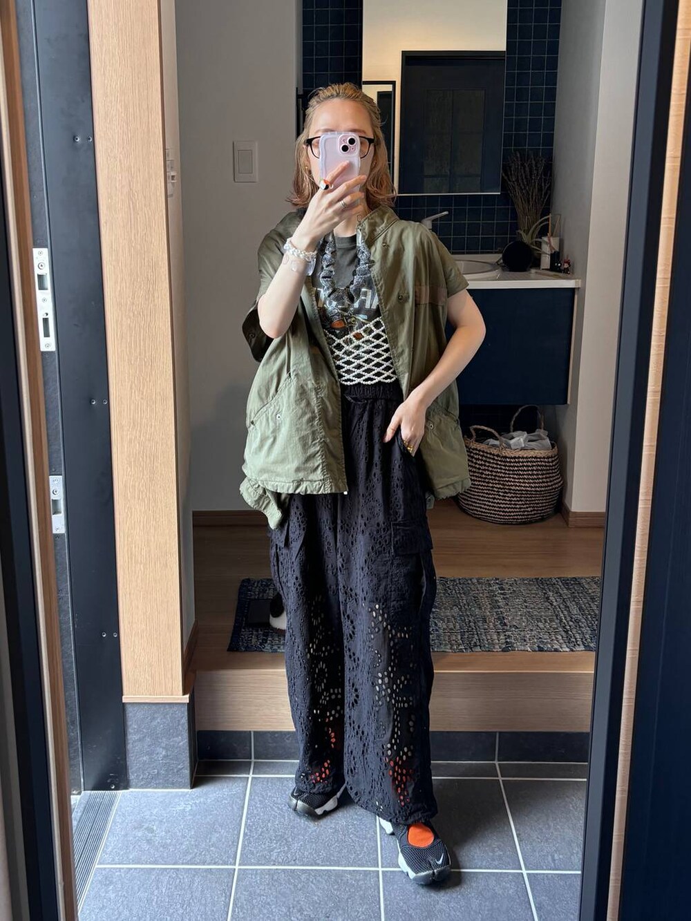 ブラック系のカーゴパンツ、イエロー系のトートバッグ、ホワイト系のベストを着用したレディースの春コーディネートの9枚目の写真