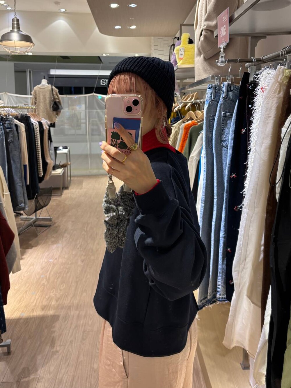 レッド系のニット/セーター、ホワイト系のスニーカー、ピンク系のカーゴパンツを着用したレディースの冬コーディネートの4枚目の写真