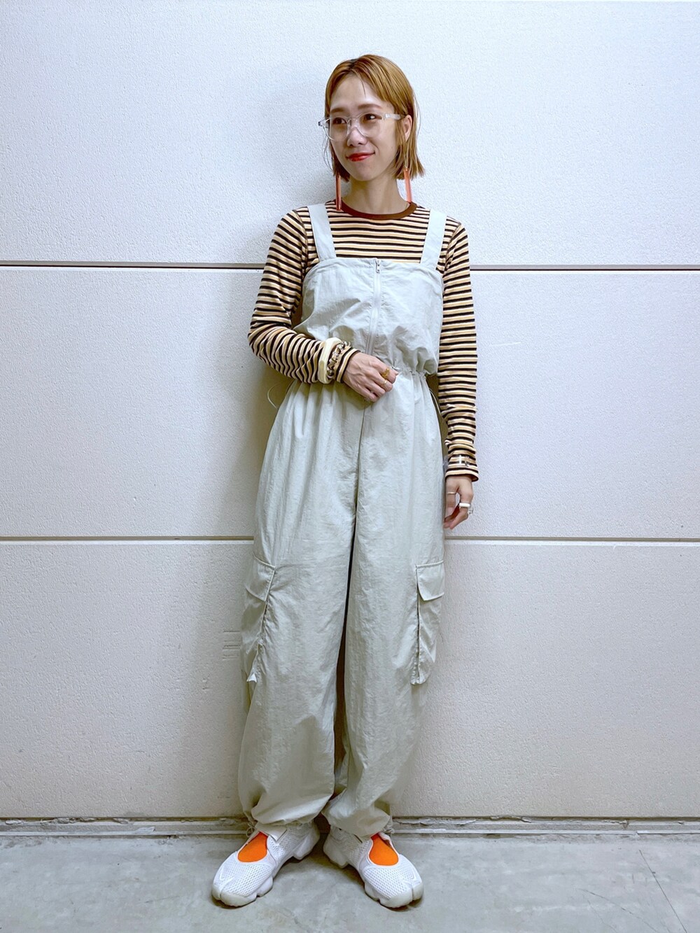 オレンジ系のTシャツ/カットソー、ホワイト系のその他パンツ、その他のメガネを着用したレディースの秋コーディネートの5枚目の写真