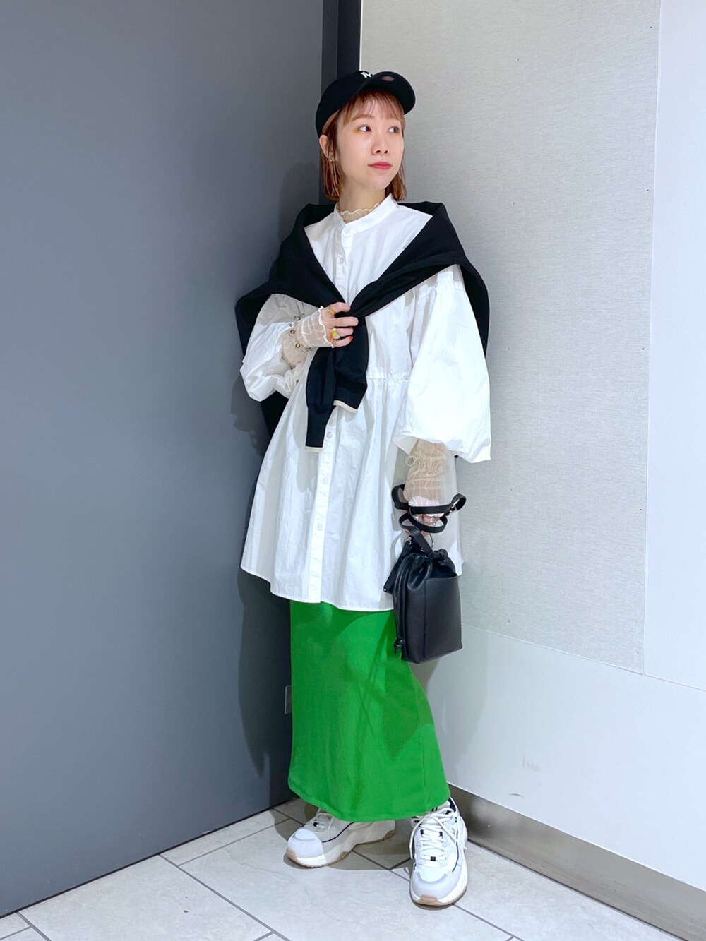 ホワイト系のスニーカー、グリーン系のスカート、ピンク系のバッグを着用したレディースの春コーディネートの10枚目の写真