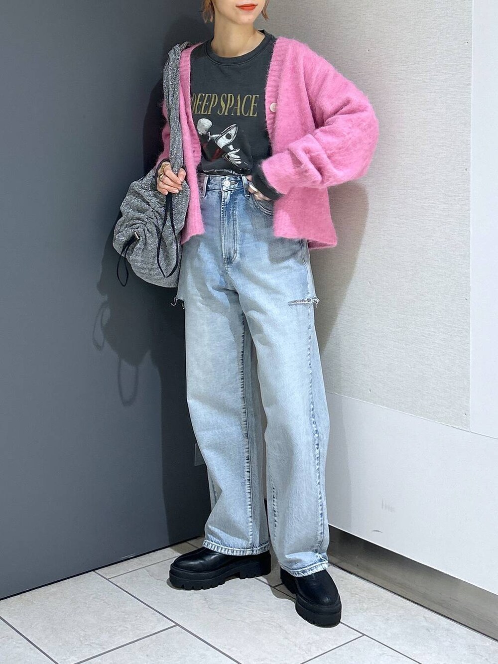 ブルー系のデニムパンツ、シルバー系のショルダーバッグ、ピンク系のカーディガン/ボレロを着用したレディースの冬コーディネートの7枚目の写真