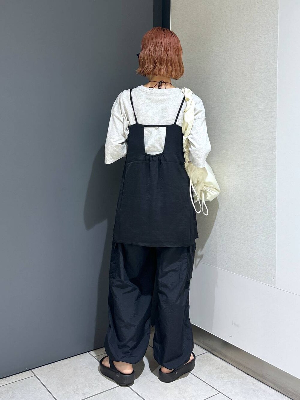 グレー系のTシャツ/カットソー、ブラック系のその他パンツ、ホワイト系のショルダーバッグを着用したレディースの夏コーディネートの5枚目の写真