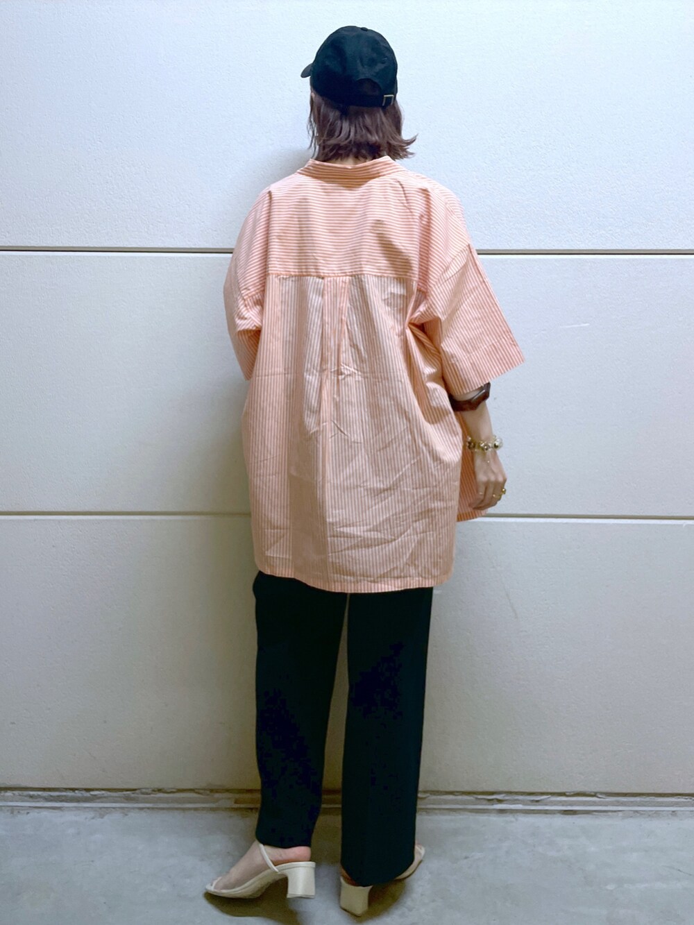 オレンジ系のシャツ/ブラウス、ブラック系のTシャツ/カットソー、ブラック系のベストを着用したレディースの春コーディネートの3枚目の写真