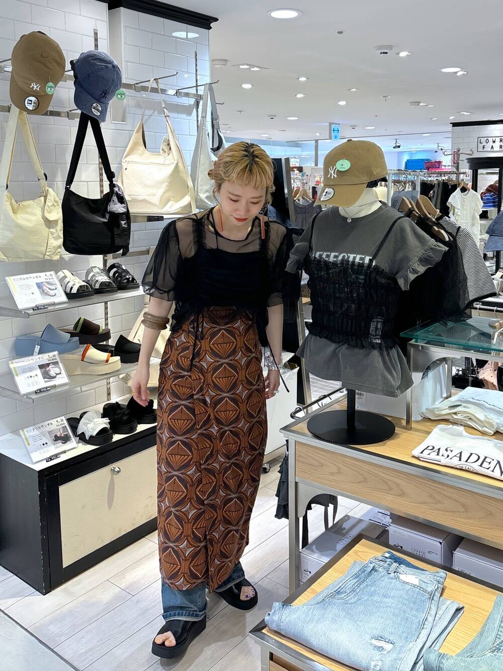 ブラック系のトートバッグ、ブラウン系のスカート、ブラック系のサンダルを着用したレディースの春コーディネートの9枚目の写真