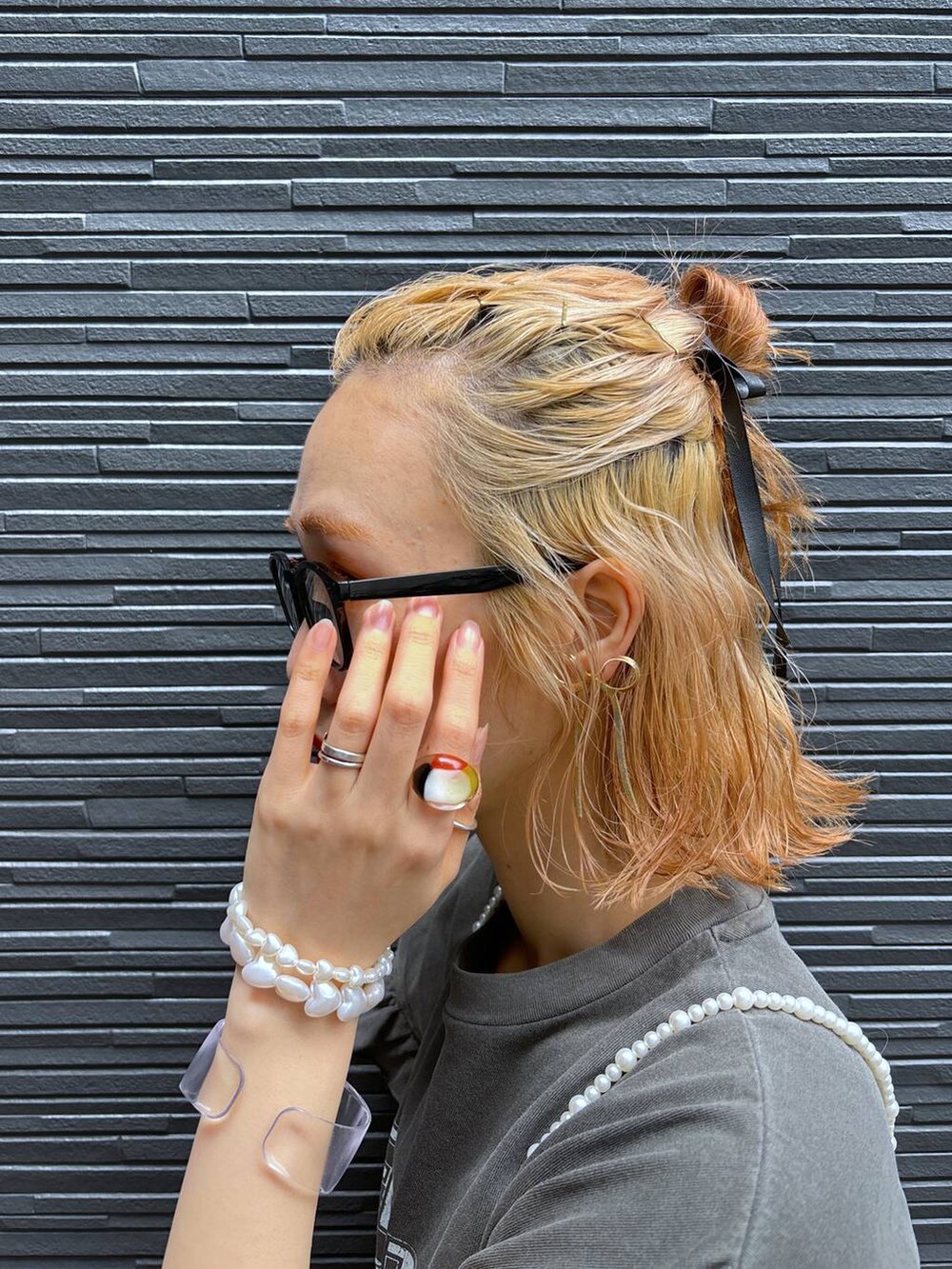 ブラック系のカーゴパンツ、イエロー系のトートバッグ、ホワイト系のベストを着用したレディースの春コーディネートの7枚目の写真