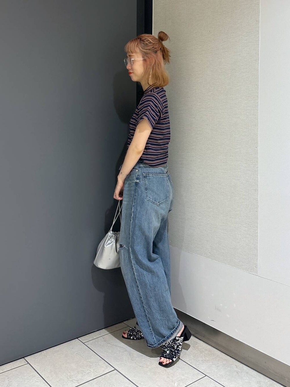 シルバー系のショルダーバッグ、ブルー系のTシャツ/カットソー、ブルー系のデニムパンツを着用したレディースの夏コーディネートの3枚目の写真