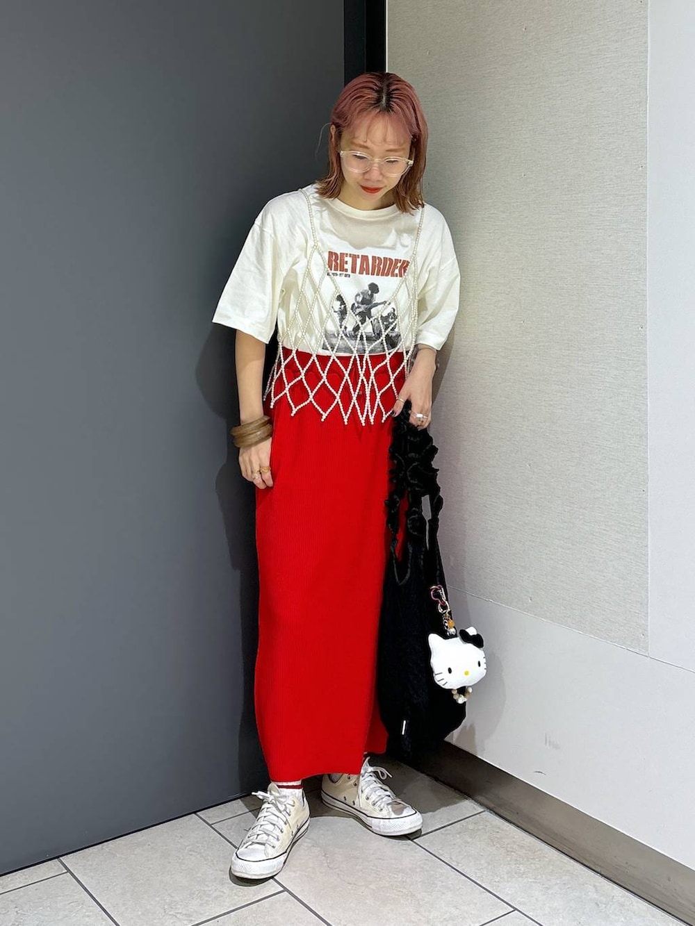 ブラック系のトートバッグ、レッド系のスカート、ホワイト系のベストを着用したレディースの夏コーディネートの6枚目の写真