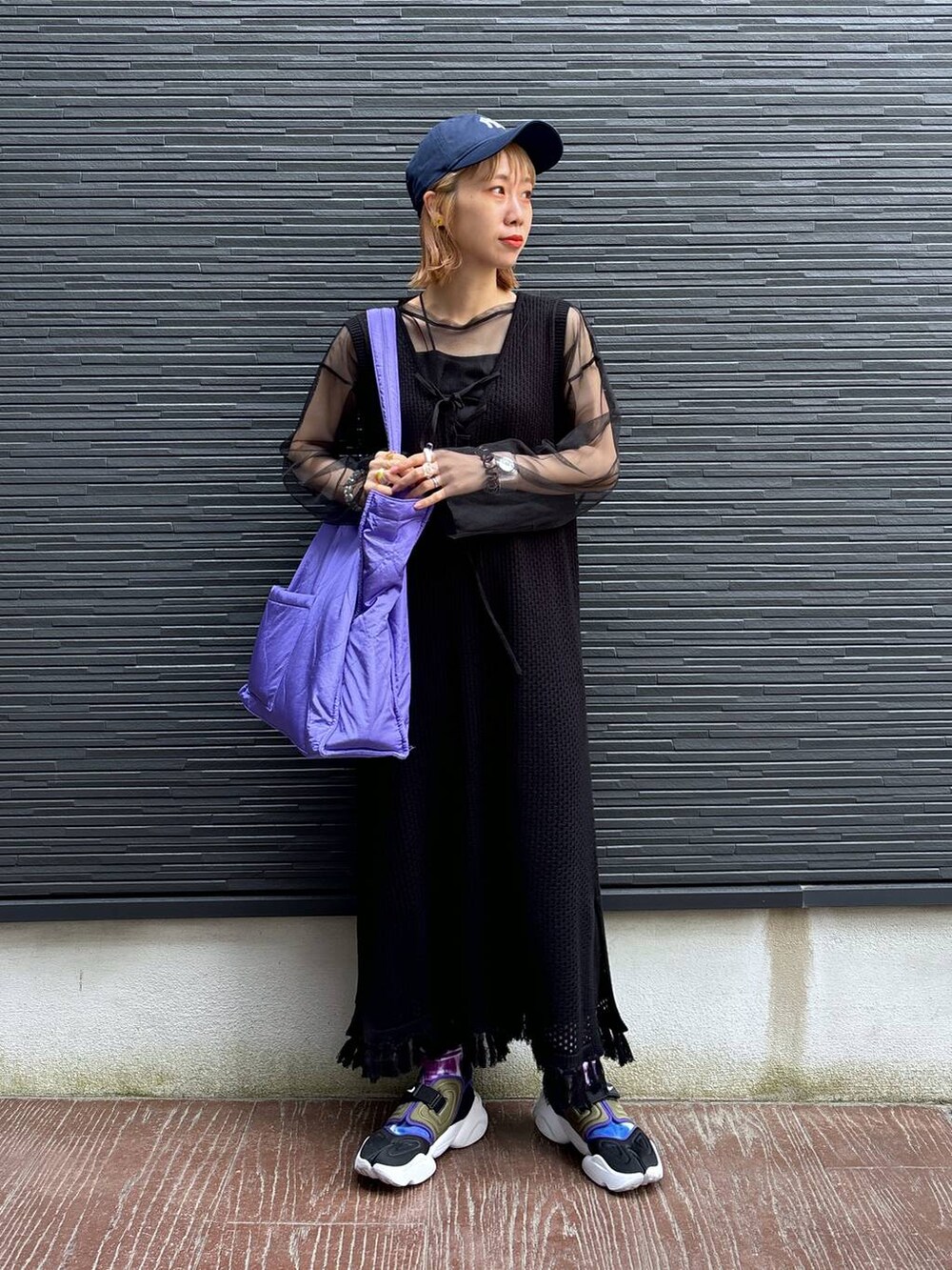 ブラック系のワンピース、パープル系のショルダーバッグ、ブラック系のスカートを着用したレディースの春コーディネートの2枚目の写真