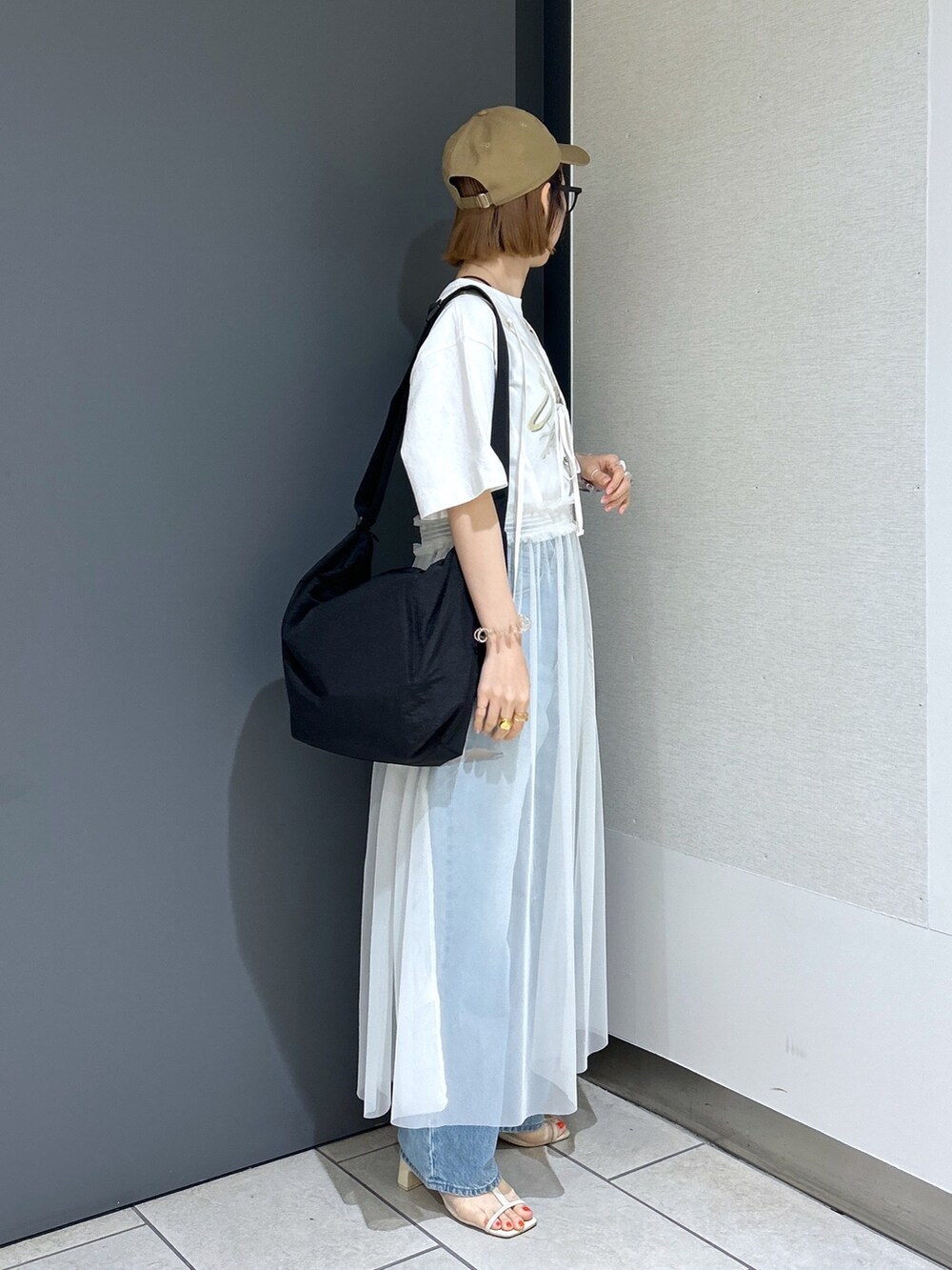 ブルー系のデニムパンツ、イエロー系のTシャツ/カットソー、ホワイト系のワンピースを着用したレディースの夏コーディネートの4枚目の写真