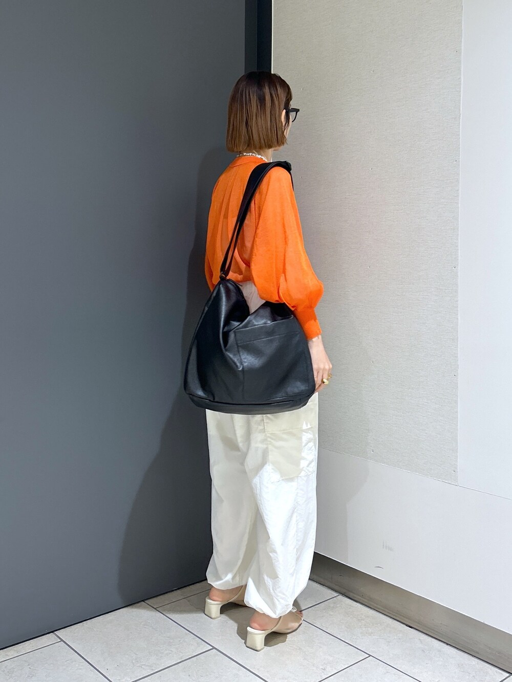 オレンジ系のカーディガン/ボレロ、ホワイト系のトップス、ホワイト系のその他パンツを着用したレディースの春コーディネートの5枚目の写真