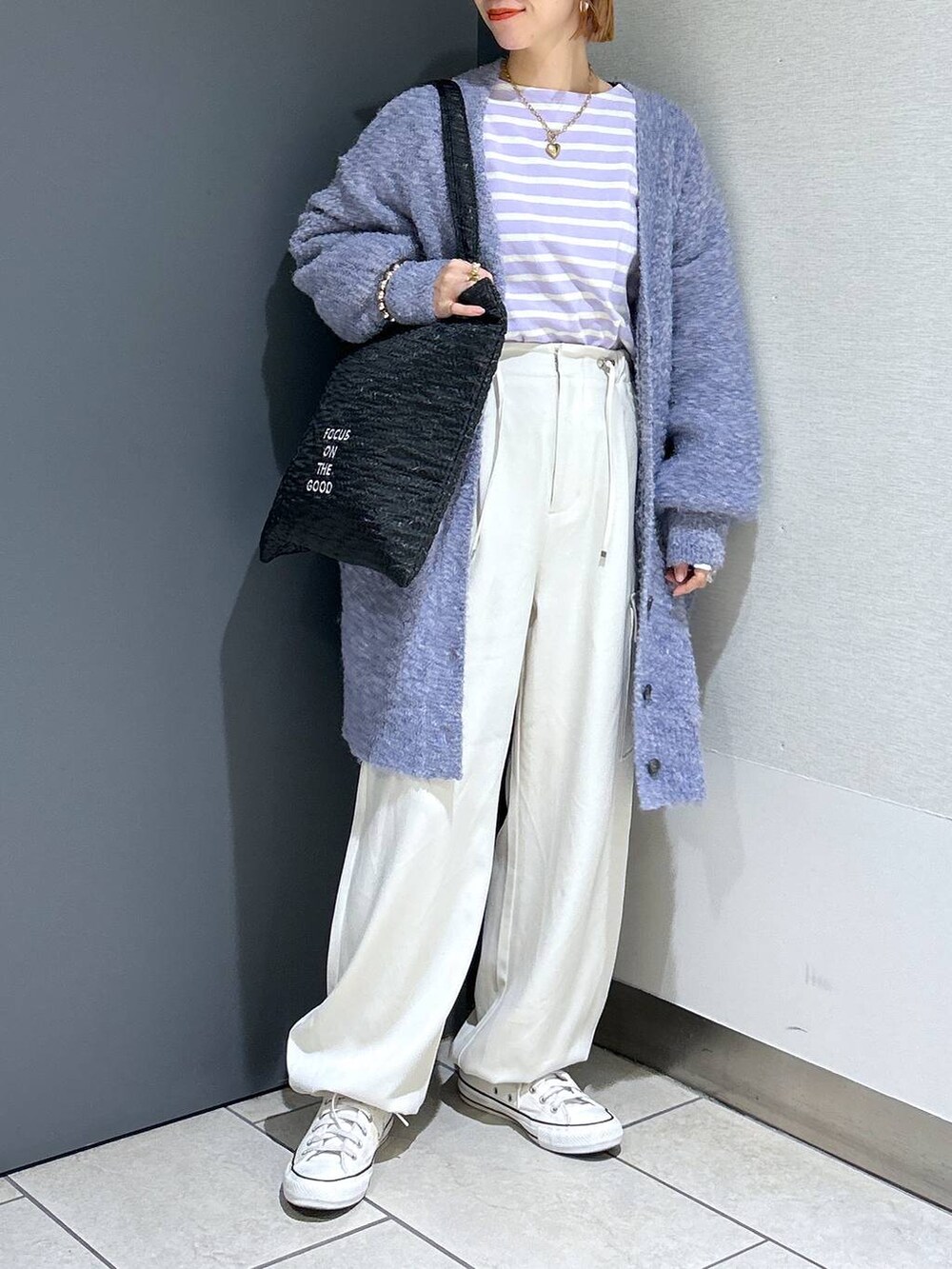 ブラック系のトートバッグ、パープル系のTシャツ/カットソー、パープル系のチュニックを着用したレディースの秋コーディネートの3枚目の写真