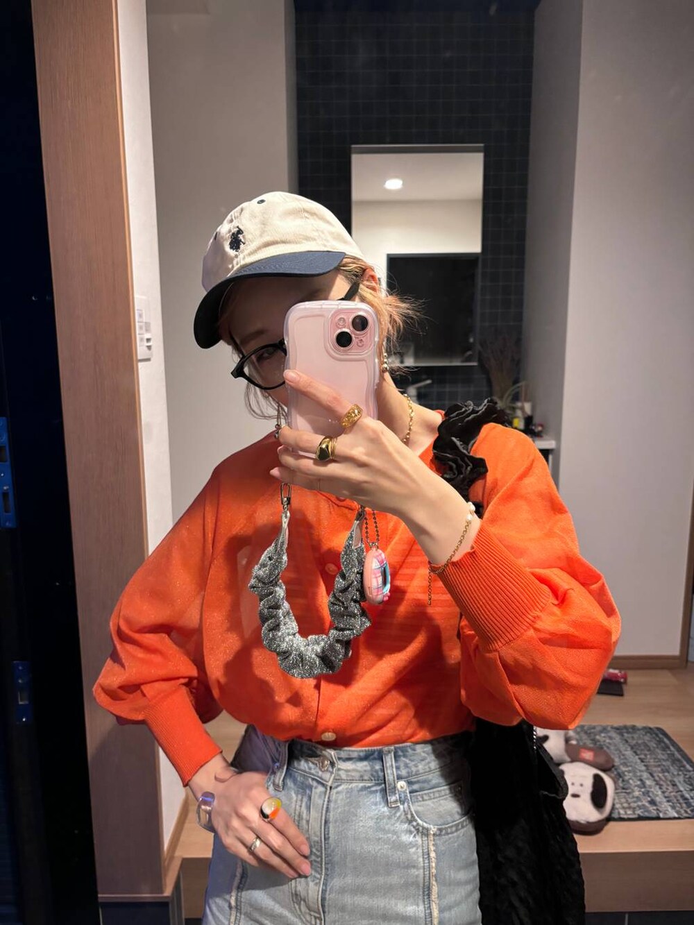 ブラック系のトートバッグ、オレンジ系のカーディガン/ボレロ、ブルー系のスカートを着用したレディースの夏コーディネートの7枚目の写真