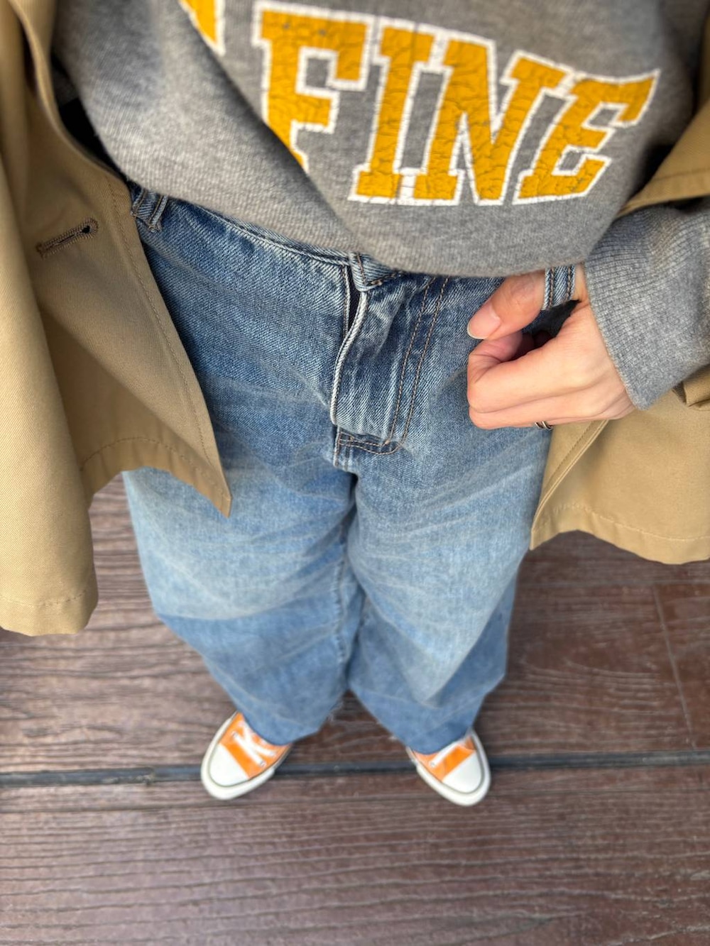 ブラウン系のトレンチコート、ブルー系のデニムパンツ、その他のネックレスを着用したレディースの春コーディネートの2枚目の写真