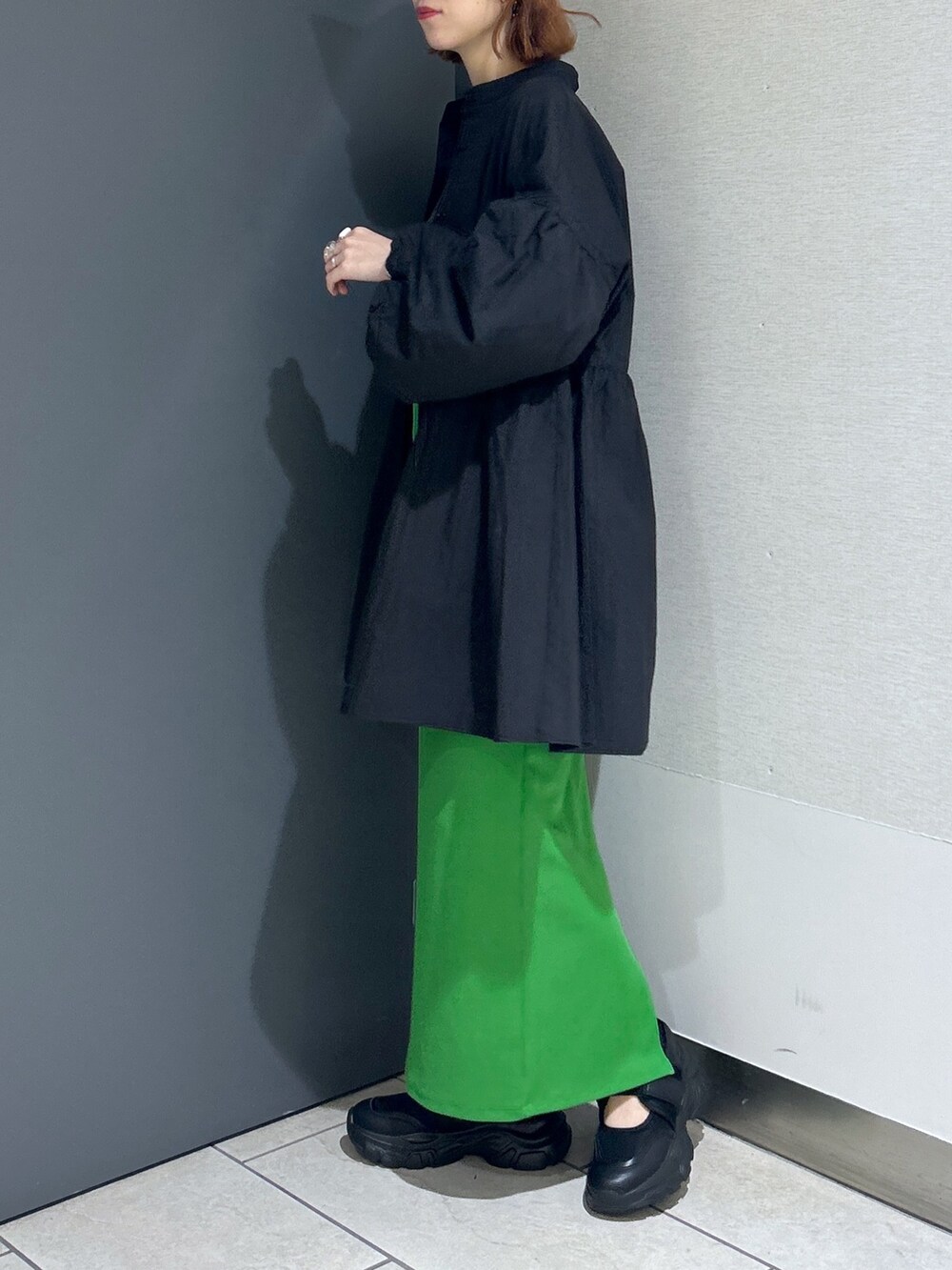 ブラック系のバッグ、グリーン系のスカート、グレー系のTシャツ/カットソーを着用したレディースの春コーディネートの6枚目の写真