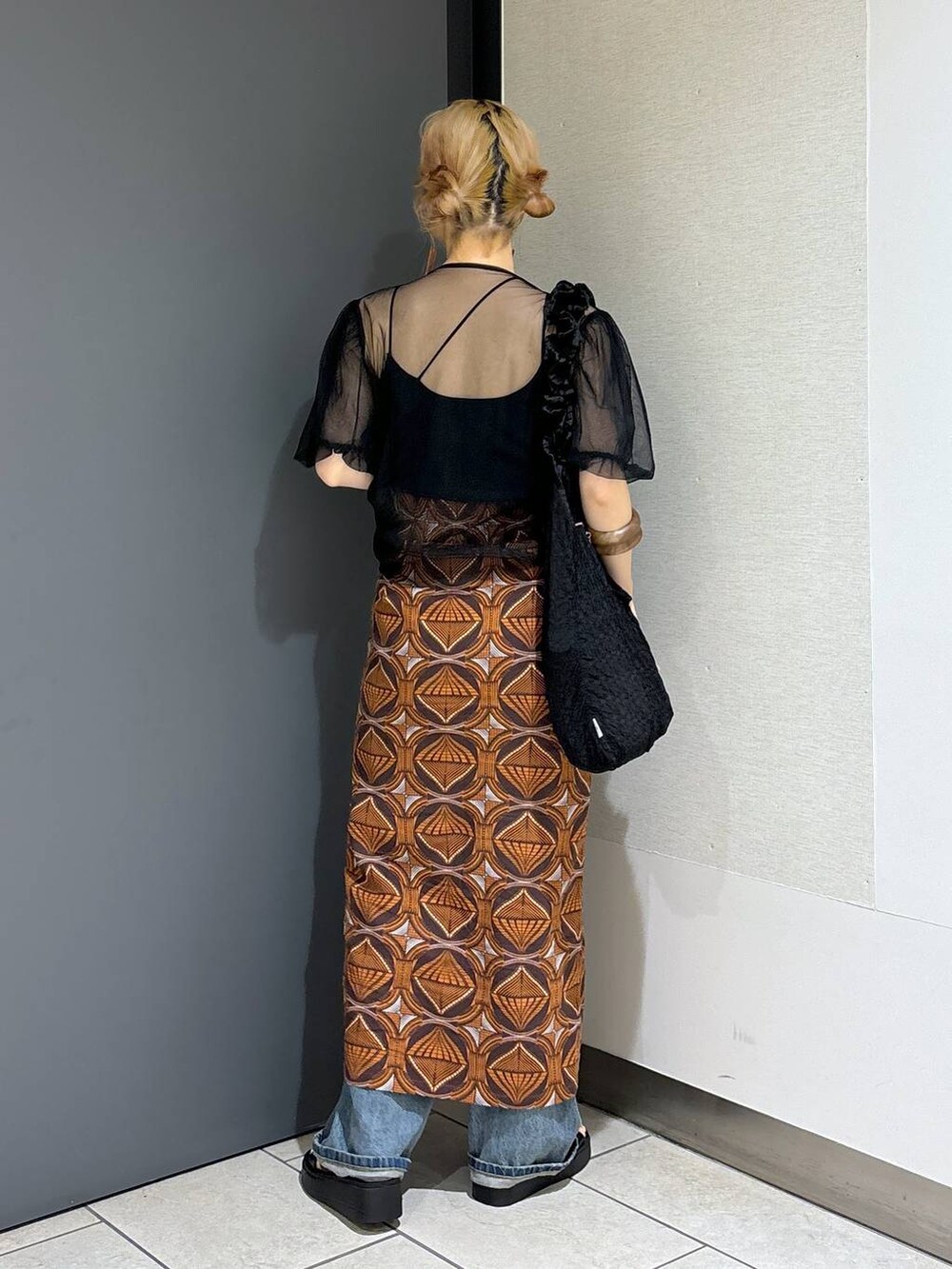 ブラック系のトートバッグ、ブラウン系のスカート、ブラック系のサンダルを着用したレディースの春コーディネートの4枚目の写真