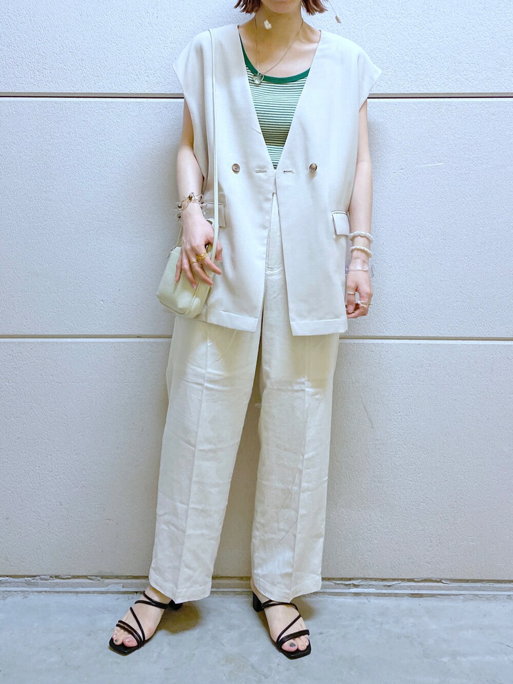 ブラック系のサンダル、グリーン系のタンクトップ、グリーン系のジャケット/アウターを着用したレディースの夏コーディネートの2枚目の写真