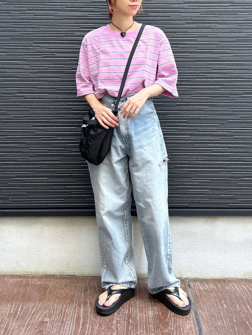 ピンク系のTシャツ/カットソー、ブラック系のショルダーバッグ、ブルー系のデニムパンツを着用したレディースの夏コーディネートの2枚目の写真
