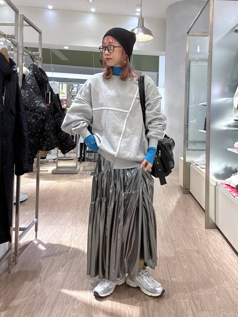 グレー系のスニーカー、ブルー系のニット/セーター、その他のショルダーバッグを着用したレディースの冬コーディネートの3枚目の写真