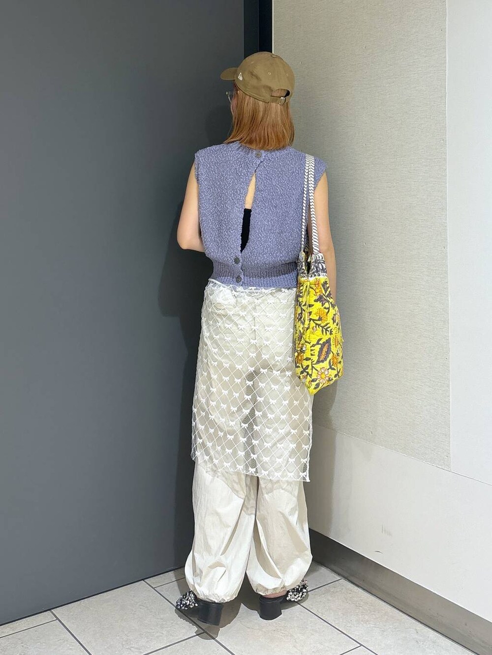 イエロー系のトートバッグ、シルバー系のサンダル、ホワイト系のその他パンツを着用したレディースの夏コーディネートの4枚目の写真