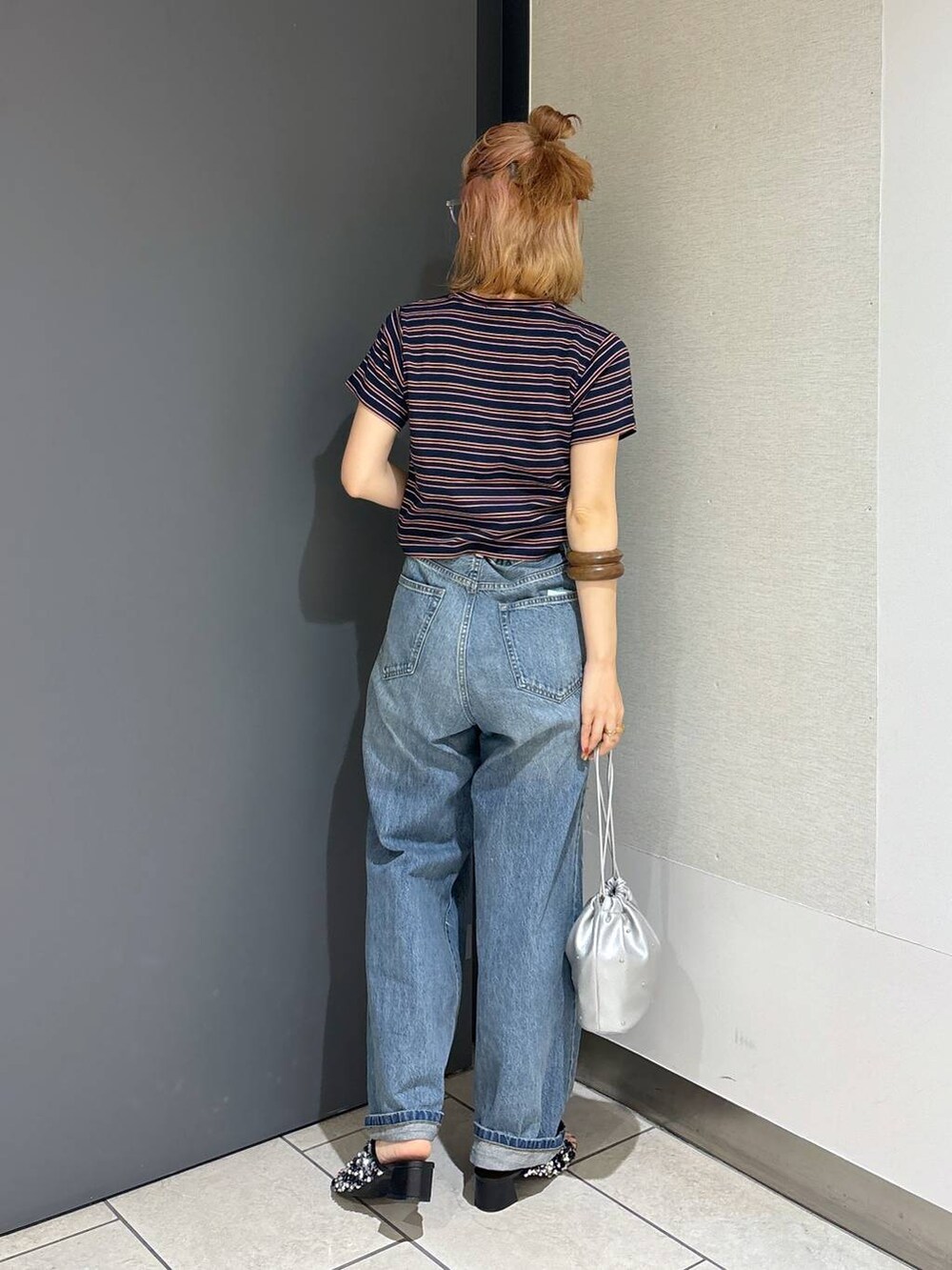 シルバー系のショルダーバッグ、ブルー系のTシャツ/カットソー、ブルー系のデニムパンツを着用したレディースの夏コーディネートの4枚目の写真