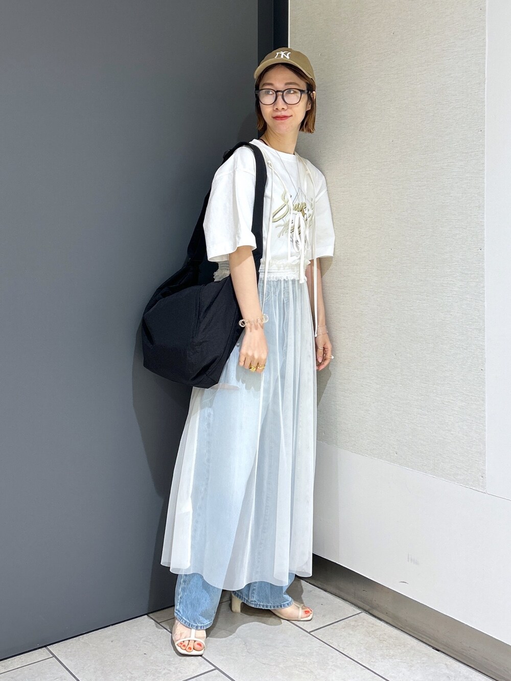 ブルー系のデニムパンツ、イエロー系のTシャツ/カットソー、ホワイト系のワンピースを着用したレディースの夏コーディネートの5枚目の写真
