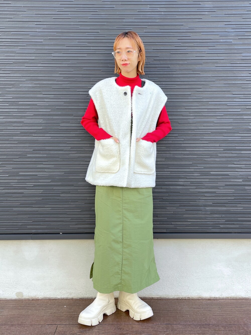 レッド系のニット/セーター、ブラック系のジャケット/アウター、ホワイト系のブーツを着用したレディースの冬コーディネートの4枚目の写真