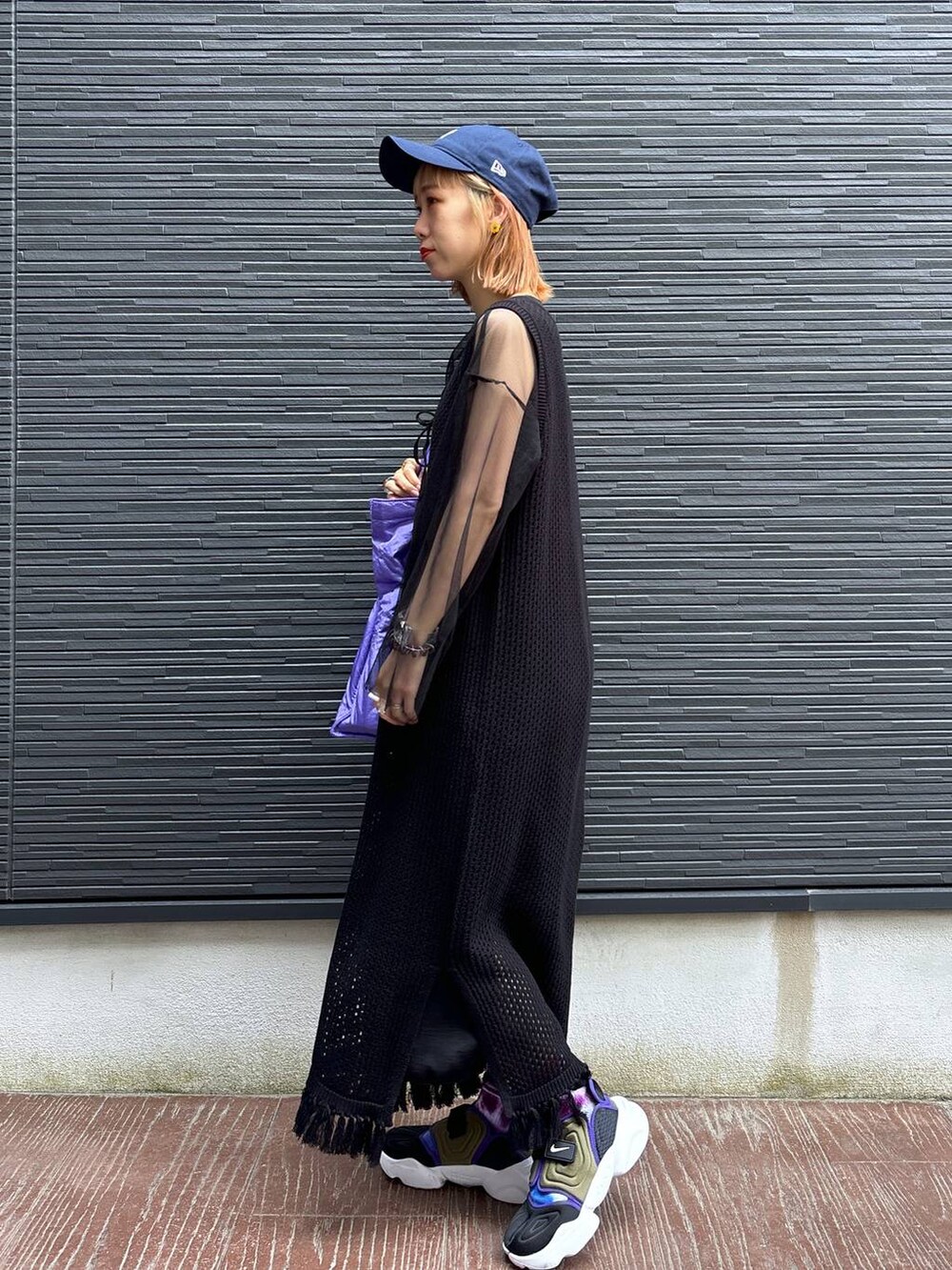 ブラック系のワンピース、パープル系のショルダーバッグ、ブラック系のスカートを着用したレディースの春コーディネートの3枚目の写真