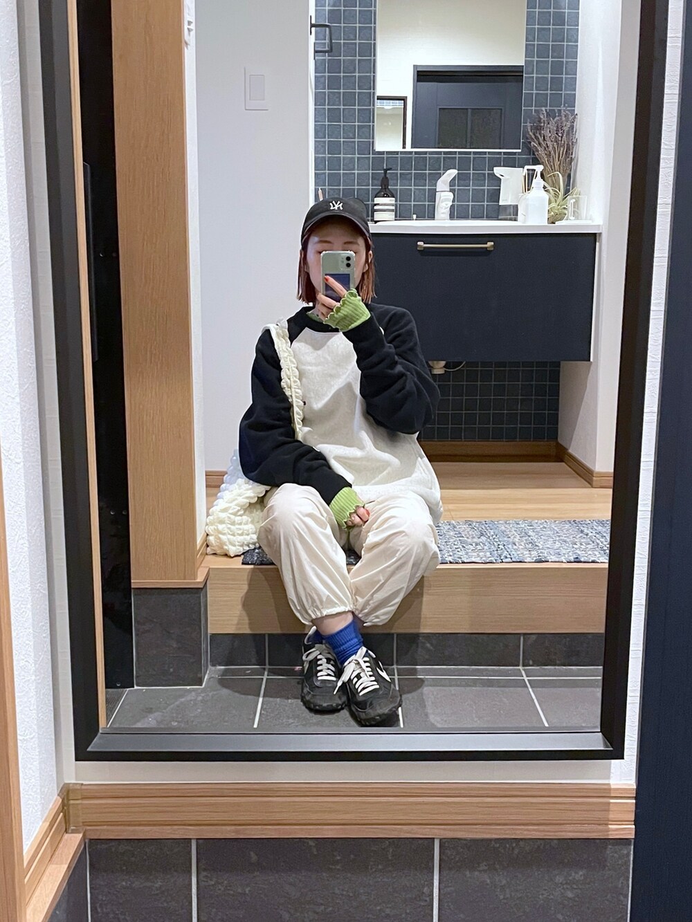 グリーン系のニット/セーター、ブラック系のスウェット、ブラック系のバッグを着用したレディースの春コーディネートの5枚目の写真