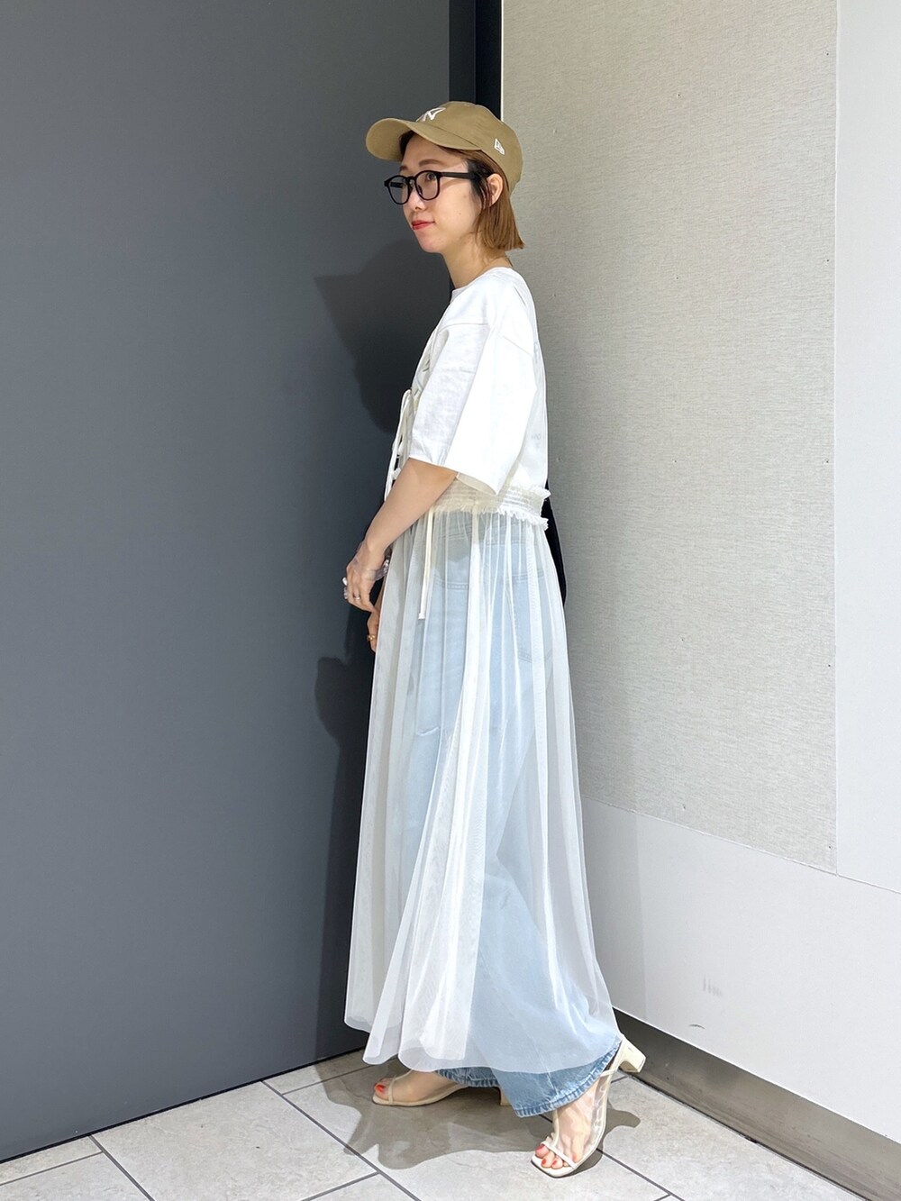 ブルー系のデニムパンツ、イエロー系のTシャツ/カットソー、ホワイト系のワンピースを着用したレディースの夏コーディネートの2枚目の写真