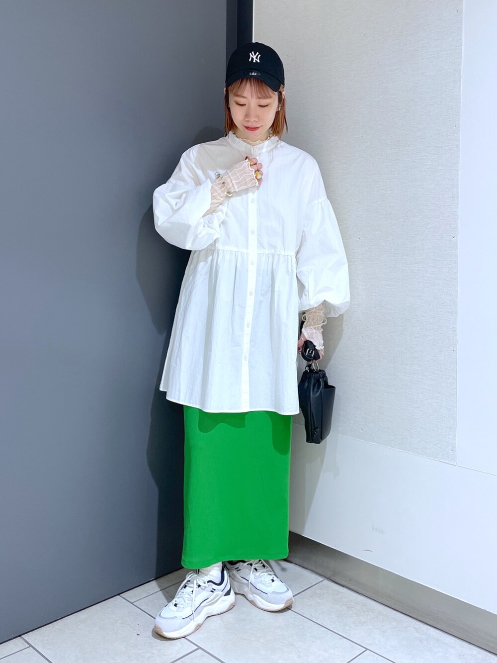 ホワイト系のスニーカー、グリーン系のスカート、ピンク系のバッグを着用したレディースの春コーディネートの7枚目の写真