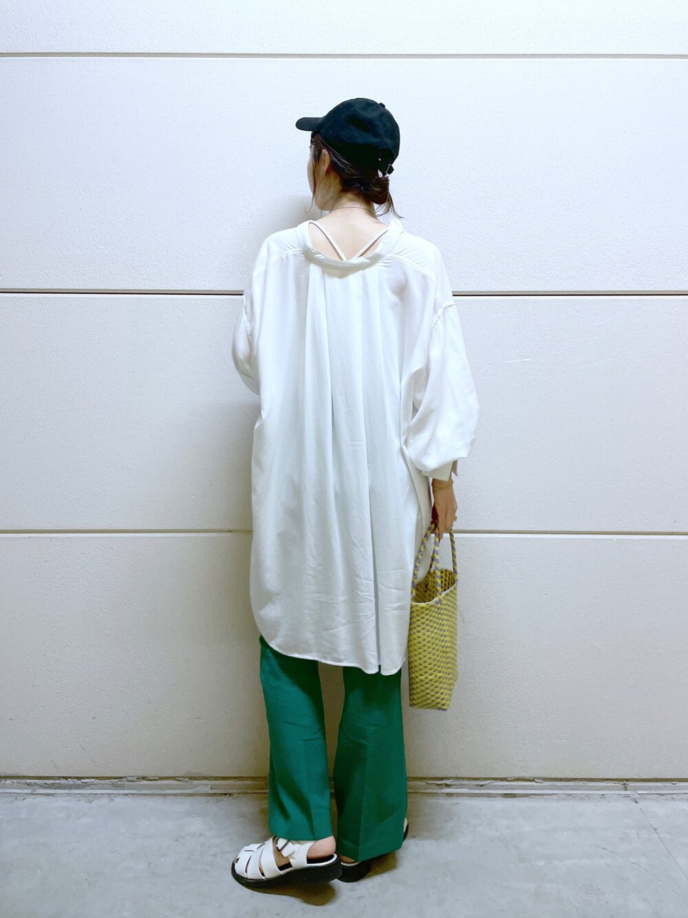 グリーン系のスラックス、パープル系のかごバッグ、ホワイト系のサンダルを着用したレディースの春コーディネートの4枚目の写真