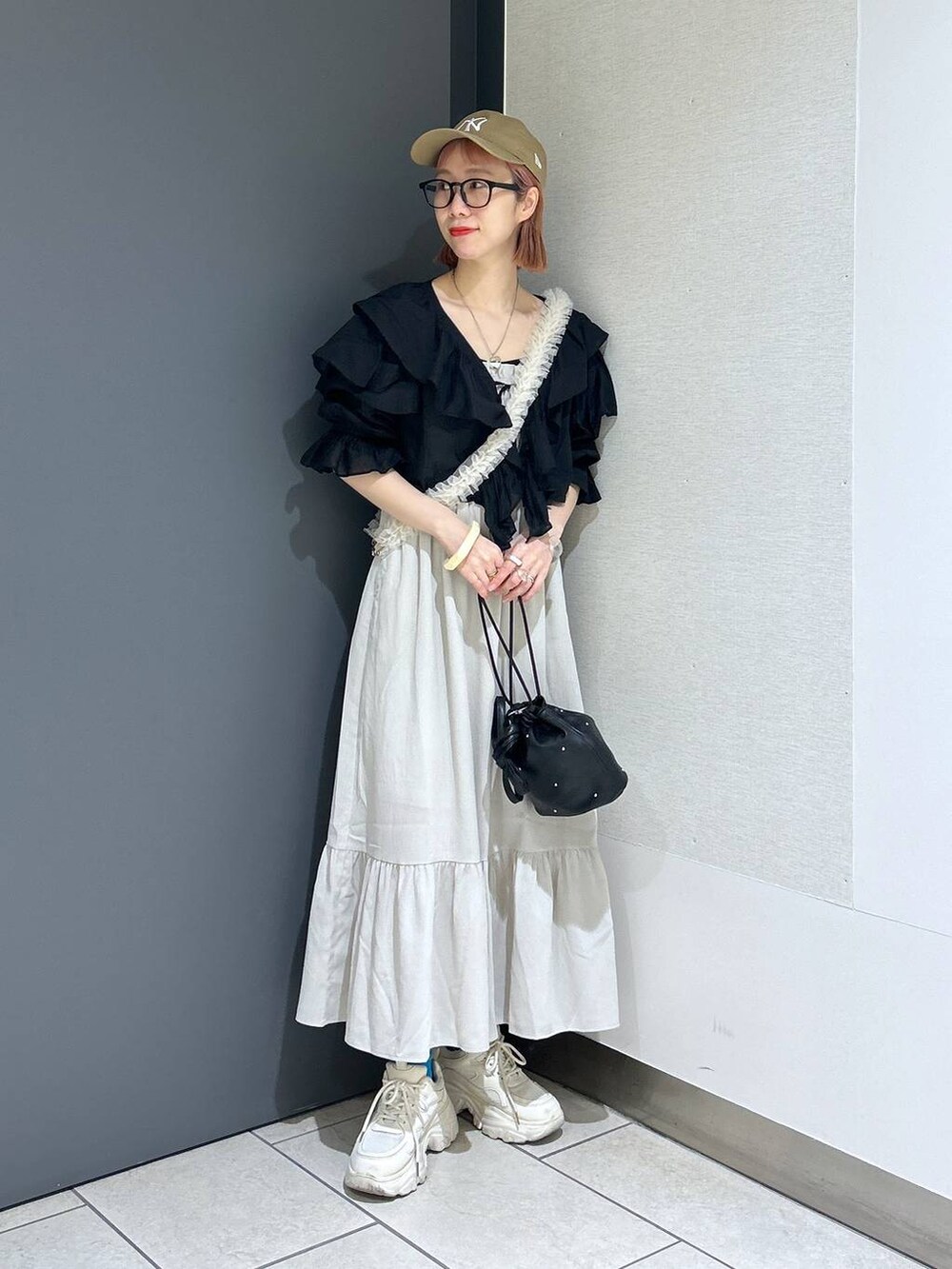 ホワイト系のワンピース、ホワイト系のスニーカー、ブラック系のショルダーバッグを着用したレディースの春コーディネートの9枚目の写真