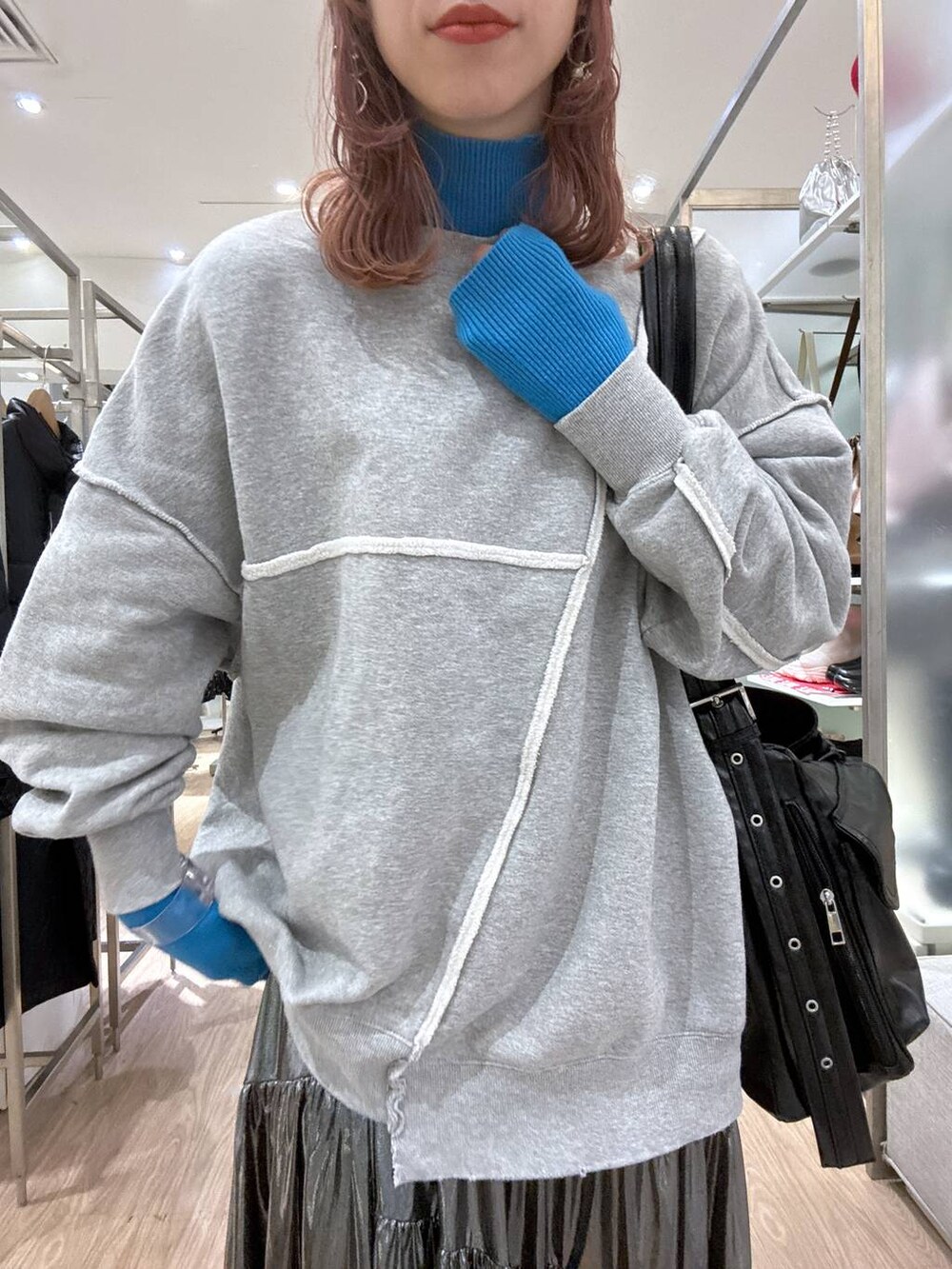 グレー系のスニーカー、ブルー系のニット/セーター、その他のショルダーバッグを着用したレディースの冬コーディネートの4枚目の写真