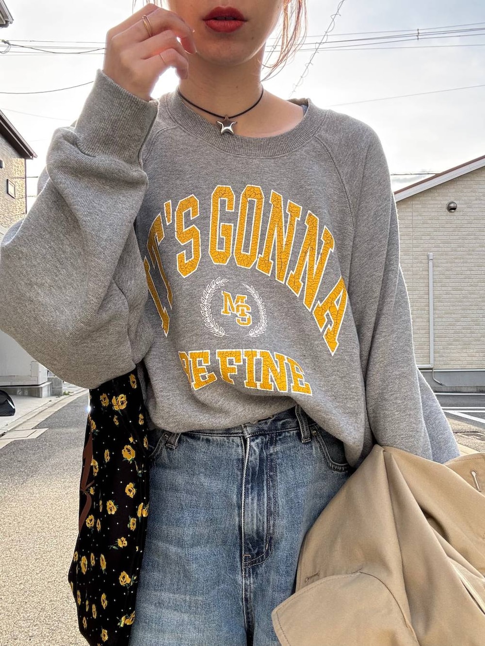 ブラウン系のトレンチコート、ブルー系のデニムパンツ、その他のネックレスを着用したレディースの春コーディネートの4枚目の写真